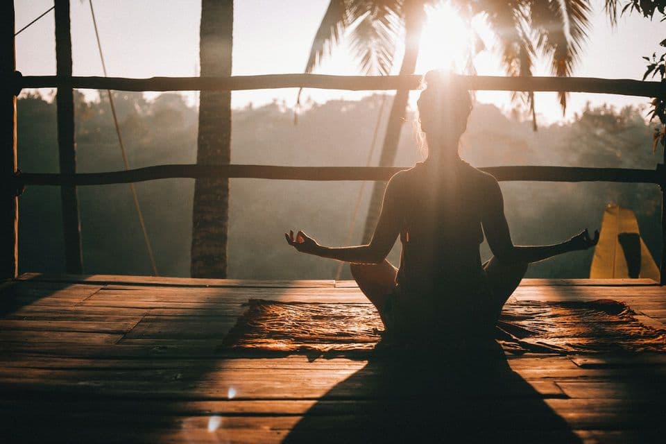 Meditation at sunset on a wooden deck